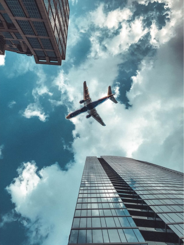 Airplane flying between buildings