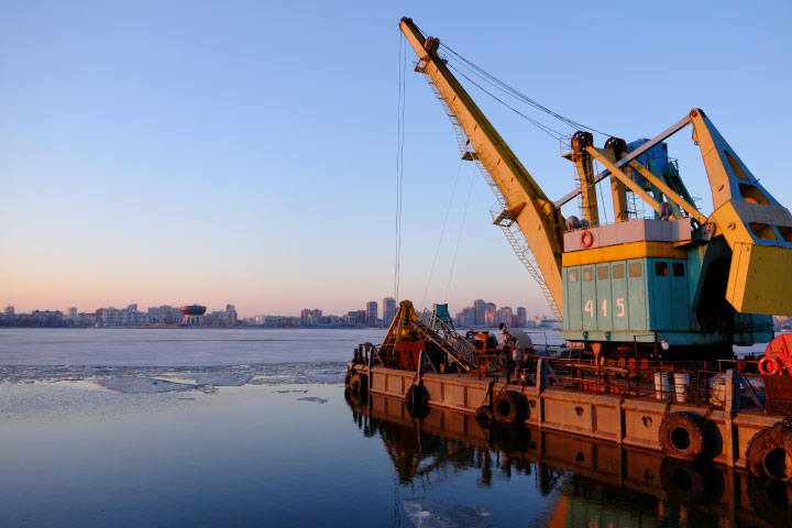 Oil rig with city and sunset